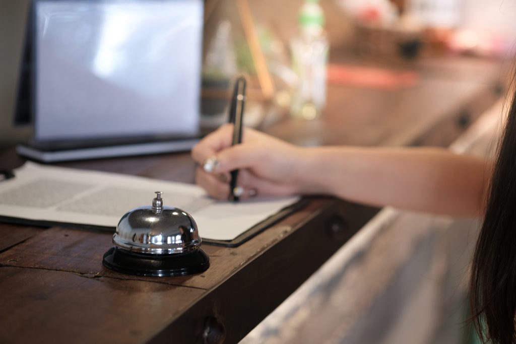 woman guest at the reception of hotel checking in