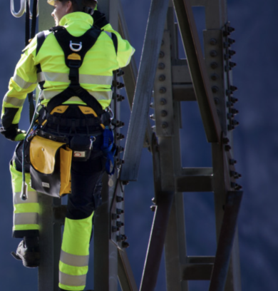 ryggen pÃ¥ en man i varselklÃ¤der framfÃ¶r en mÃ¶rkblÃ¥ bakgrund